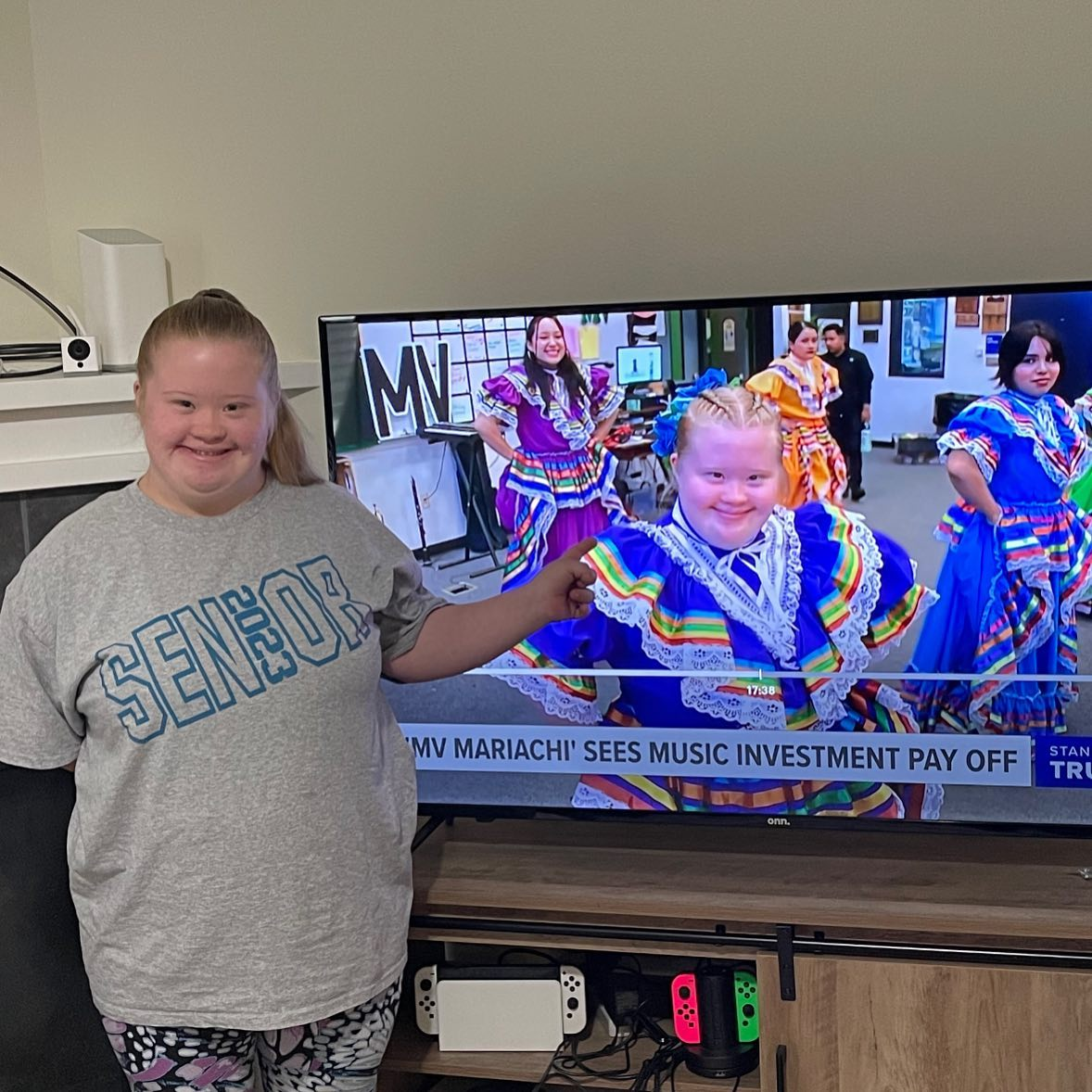 Student poses in front of TV