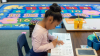 Student writing at her desk